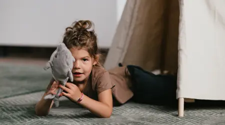 Meisje speelt met knuffel in tipi