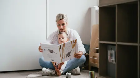 Pedagogisch Medewerker leest een boek voor aan peuter