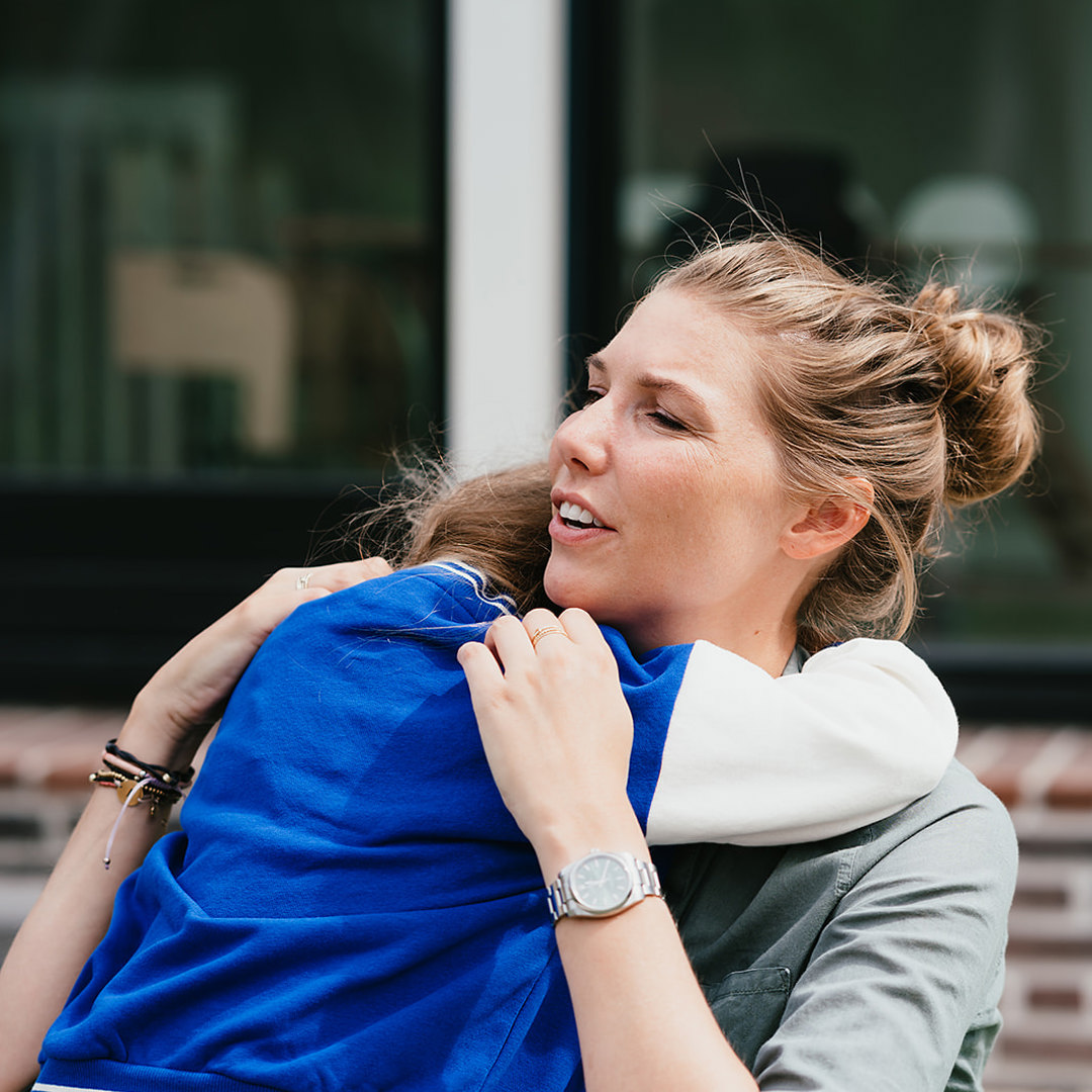 Pedagogisch Medewerker geeft meisje een knuffel