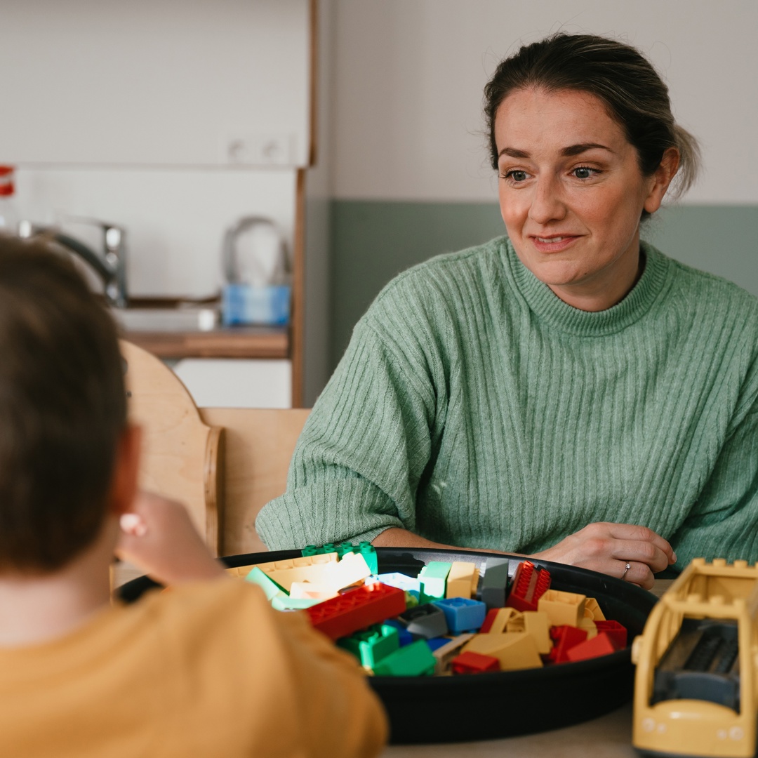 Vrouw praat en speelt met kind