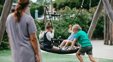 Kinderen spelen op schommel in tuin