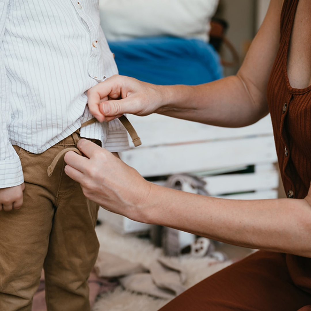 Vrouw doet broek aan bij peuter