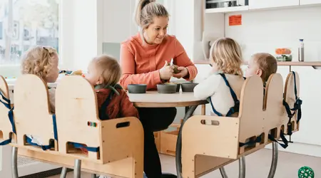 Pedagogisch Medewerker snijdt fruit voor kinderen aan tafel