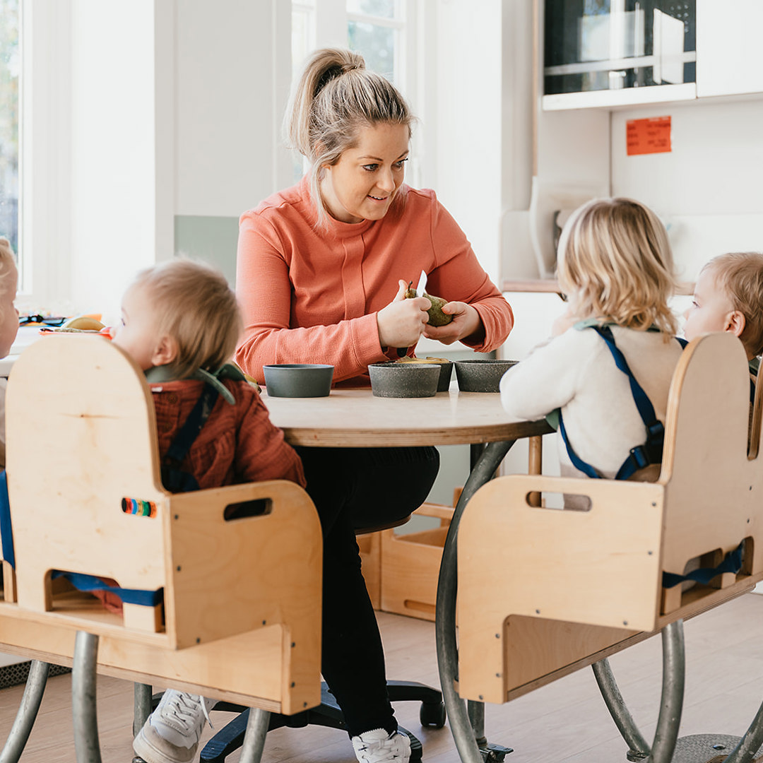 Pedagogisch Medewerker snijdt fruit voor kinderen aan tafel