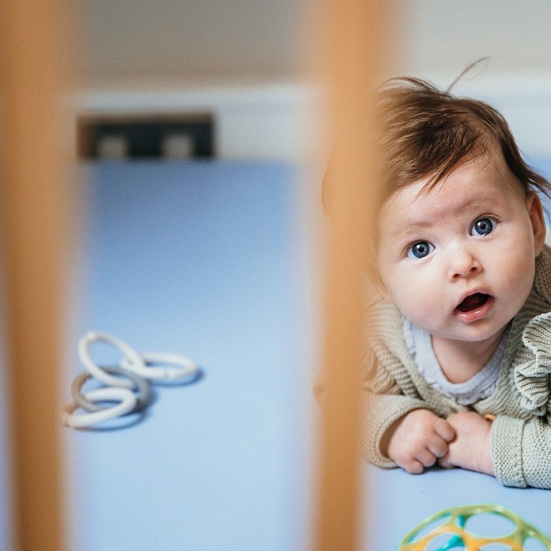 Baby ligt in grondbox