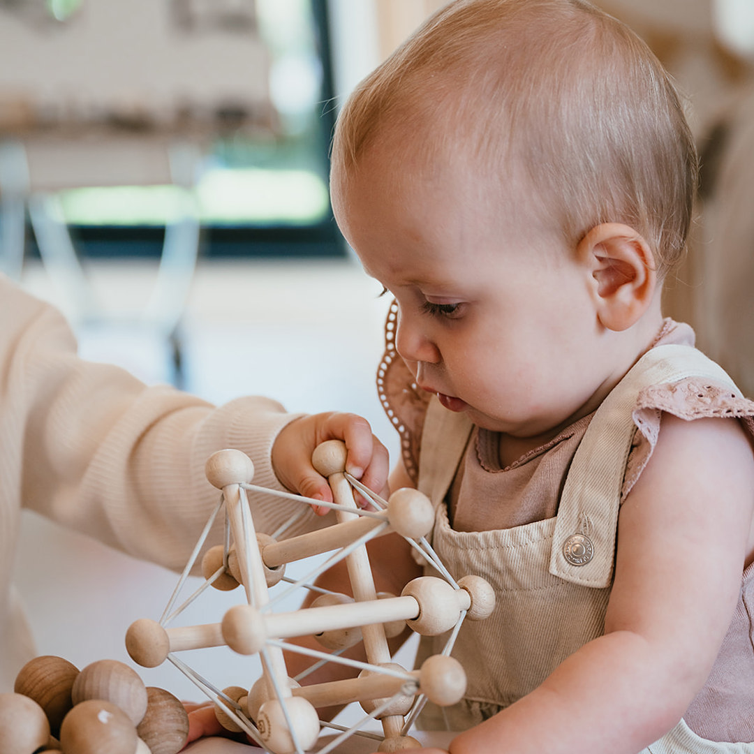 Baby speelt met passief speelgoed bij kinderopvang CompaNanny 