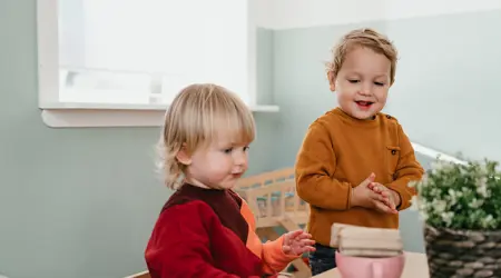 Twee kinderen spelen aan tafel met speelgoed