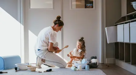 Pedagogisch Medewerker en meisje spelen met speelgoed