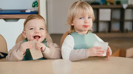 Kinderen eten en drinken aan tafel