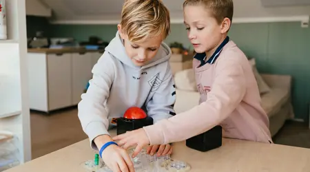 Twee jongens spelen een spel aan tafel